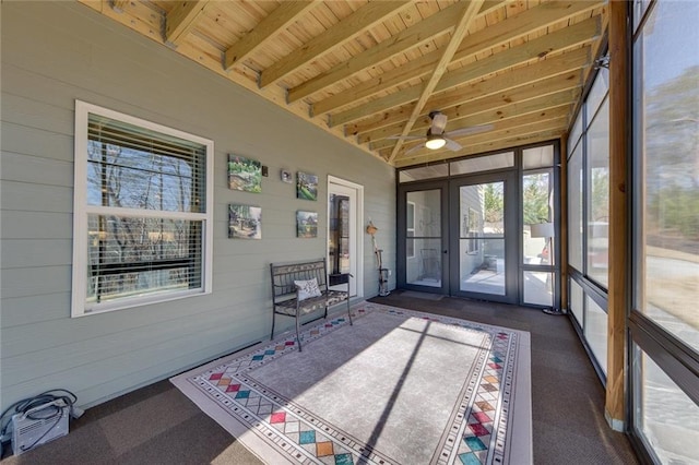 unfurnished sunroom featuring ceiling fan, beam ceiling, and wooden ceiling