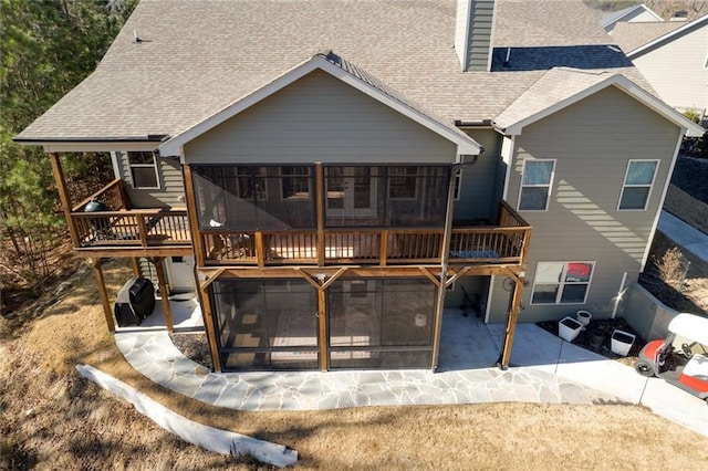 back of property featuring a sunroom and a deck