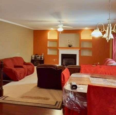 living room featuring a fireplace, crown molding, and ceiling fan with notable chandelier