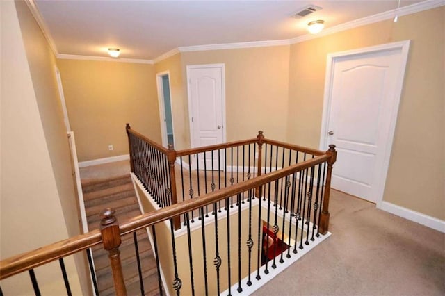 hallway with visible vents, baseboards, crown molding, an upstairs landing, and carpet floors