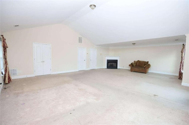 unfurnished living room featuring a fireplace, visible vents, carpet flooring, vaulted ceiling, and baseboards