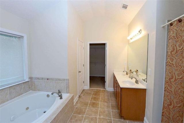 bathroom with tile patterned flooring, a sink, a whirlpool tub, and double vanity