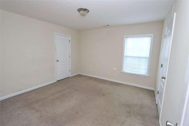 unfurnished room with carpet and baseboards