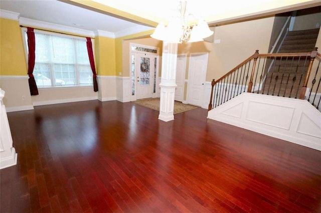 interior space featuring ornate columns, crown molding, stairs, and wood finished floors