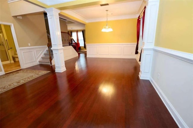 unfurnished dining area with decorative columns, visible vents, stairway, ornamental molding, and dark wood-type flooring