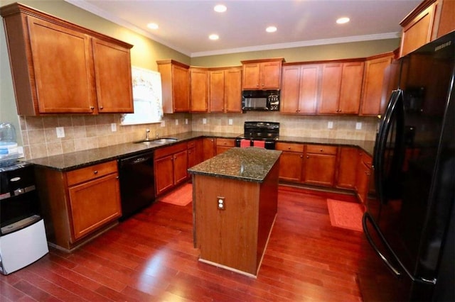 kitchen with dark wood-style floors, a kitchen island, ornamental molding, brown cabinets, and black appliances