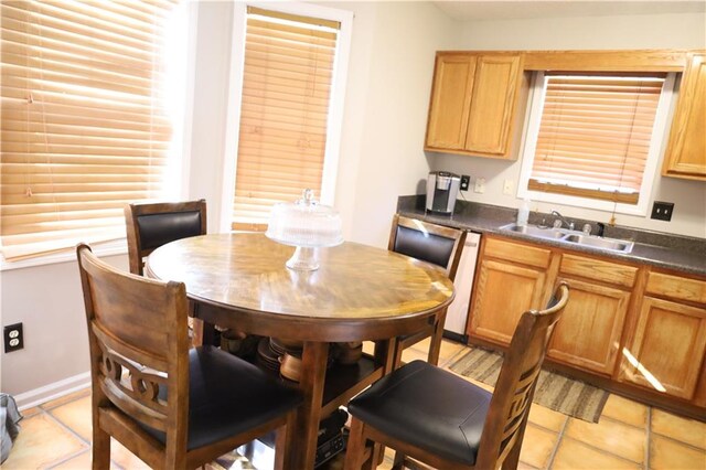 kitchen featuring dishwasher, sink, and light tile patterned flooring