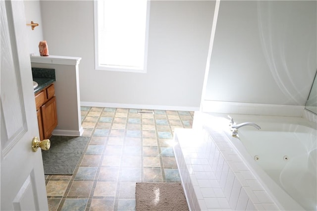 bathroom featuring vanity, a relaxing tiled tub, and tile patterned floors