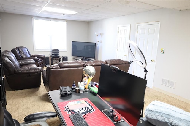 carpeted living room with a drop ceiling