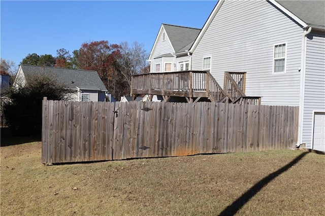 rear view of property featuring a lawn and a wooden deck