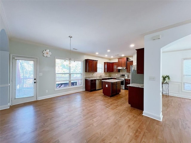 kitchen featuring a center island, stainless steel appliances, backsplash, hardwood / wood-style floors, and pendant lighting