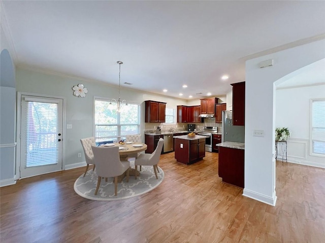 dining space featuring crown molding and light hardwood / wood-style flooring