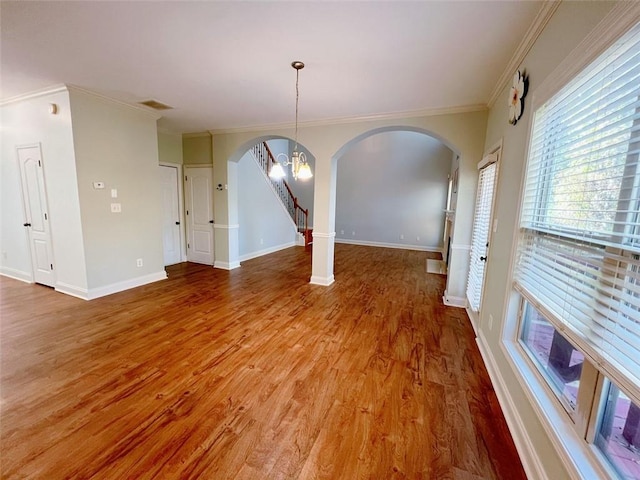 unfurnished dining area with a chandelier, hardwood / wood-style flooring, and ornamental molding