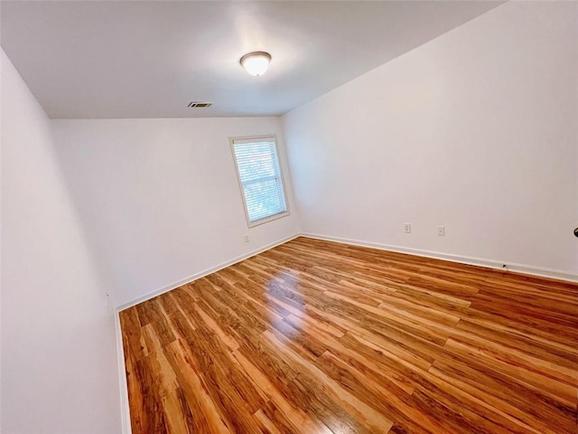 unfurnished room featuring light wood-type flooring and lofted ceiling