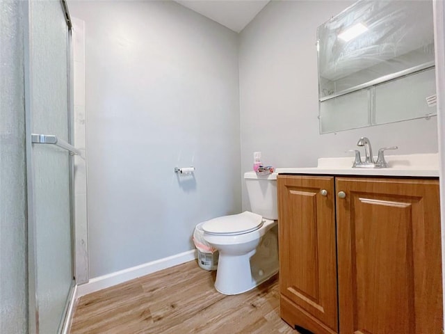 bathroom with walk in shower, vanity, wood-type flooring, and toilet