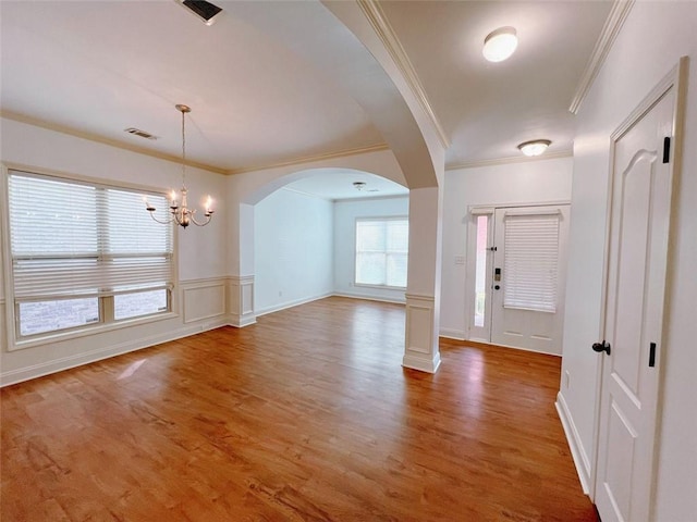 entryway featuring hardwood / wood-style floors, ornamental molding, and a notable chandelier