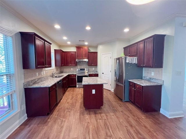 kitchen featuring crown molding, sink, a kitchen island, wood-type flooring, and stainless steel appliances