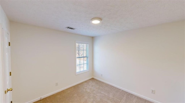 carpeted spare room with a textured ceiling