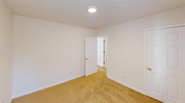 unfurnished bedroom featuring light carpet