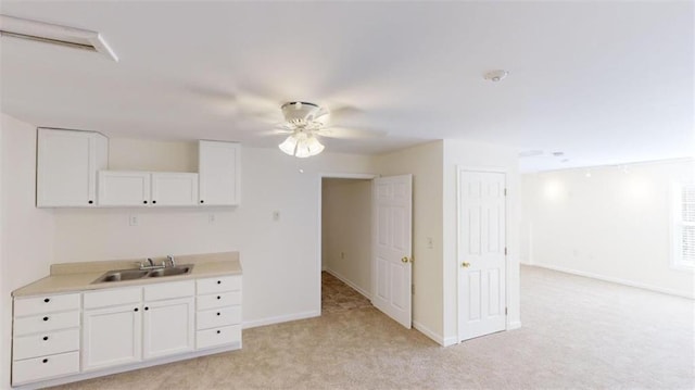 kitchen featuring white cabinetry, sink, and light colored carpet