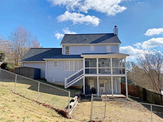 rear view of house featuring a yard, a sunroom, and a patio