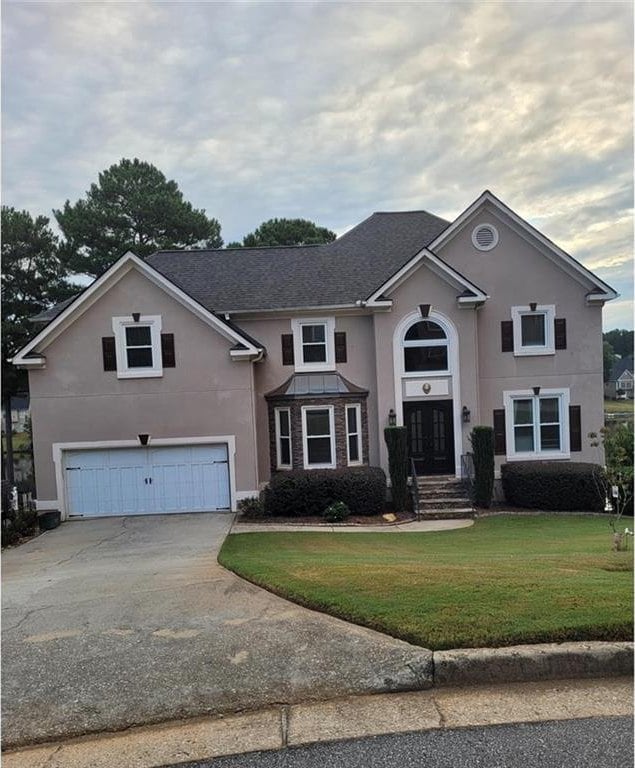 view of front of house featuring a front lawn and a garage