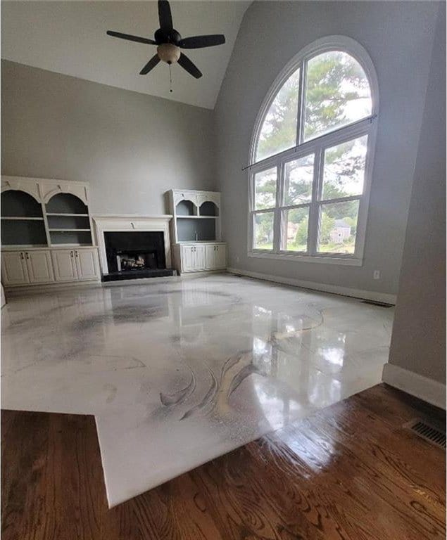 unfurnished living room featuring light hardwood / wood-style flooring, ceiling fan, and vaulted ceiling