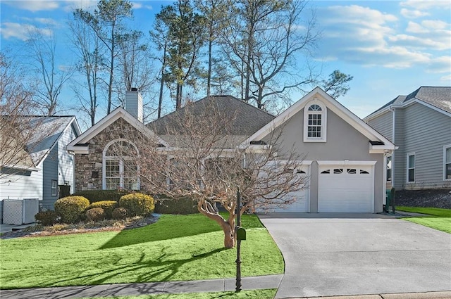 front facade with cooling unit, a garage, and a front yard