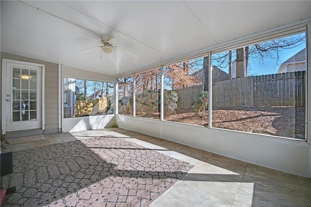 unfurnished sunroom featuring ceiling fan