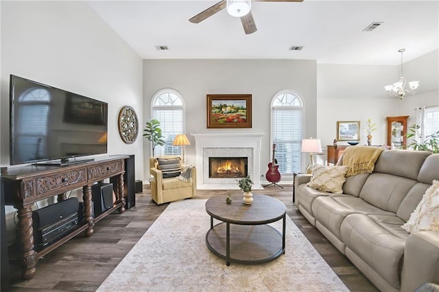 living room featuring a fireplace, dark hardwood / wood-style flooring, ceiling fan with notable chandelier, and a wealth of natural light