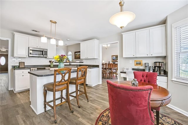 kitchen featuring pendant lighting, a center island, and white cabinets