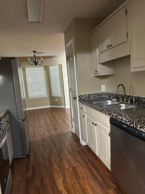 kitchen featuring a notable chandelier, dark wood-type flooring, stainless steel appliances, sink, and white cabinets