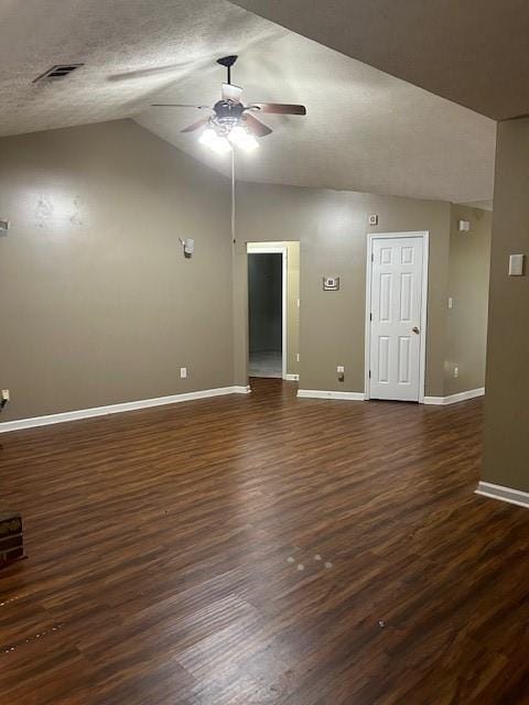 empty room featuring ceiling fan, dark hardwood / wood-style floors, a textured ceiling, and vaulted ceiling