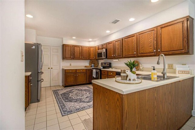 1484 Winston Pl, Decatur, GA 30033 - kitchen featuring stainless steel appliances, a peninsula, a sink, light tile patterned flooring, and visible vents