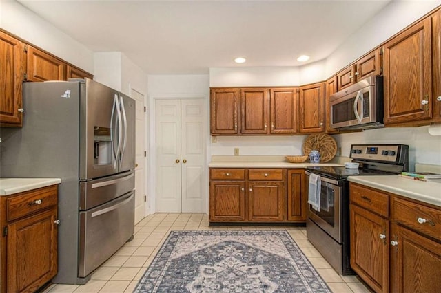 1484 Winston Pl, Decatur, GA 30033 - kitchen with brown cabinets, appliances with stainless steel finishes, light countertops, and light tile patterned floors