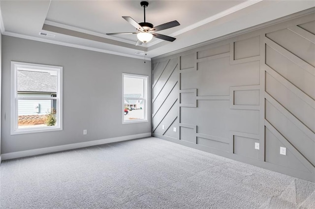 unfurnished bedroom featuring a tray ceiling, crown molding, ceiling fan, and light carpet