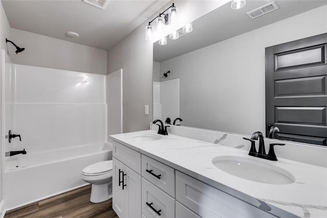 full bathroom with bathtub / shower combination, hardwood / wood-style floors, vanity, and toilet