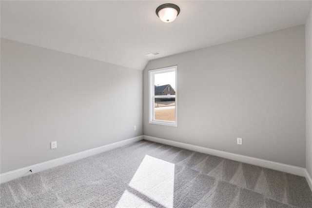 empty room with carpet flooring and lofted ceiling