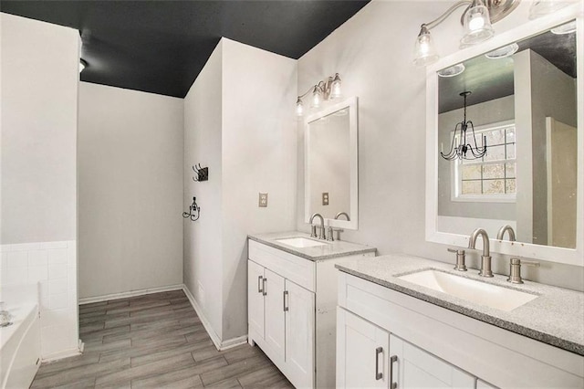 bathroom featuring a bath, vanity, and an inviting chandelier