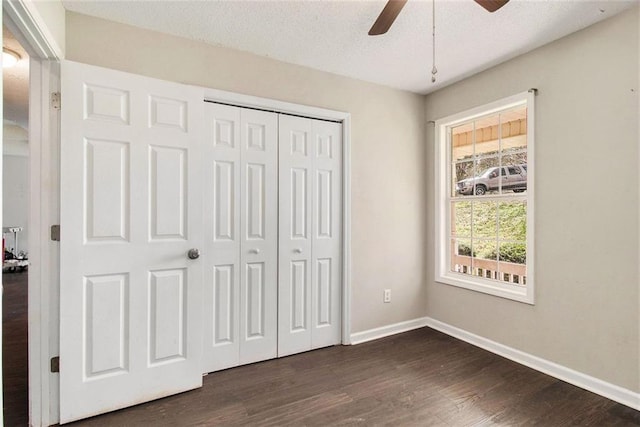 unfurnished bedroom with dark hardwood / wood-style flooring, ceiling fan, a closet, and a textured ceiling