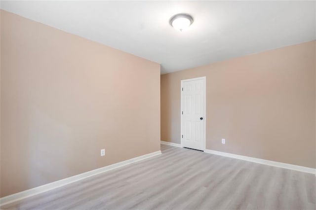 empty room featuring light wood-style flooring and baseboards