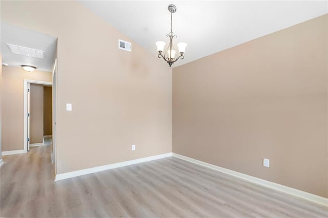 unfurnished room with light wood finished floors, an inviting chandelier, visible vents, and baseboards