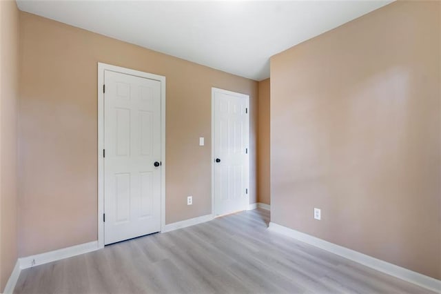 unfurnished bedroom featuring baseboards and light wood-style floors