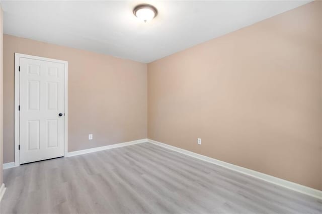 unfurnished room featuring baseboards and light wood-style floors