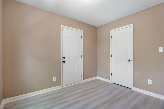 unfurnished room featuring light wood-type flooring and baseboards
