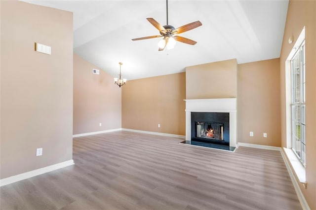 unfurnished living room featuring vaulted ceiling, baseboards, and wood finished floors