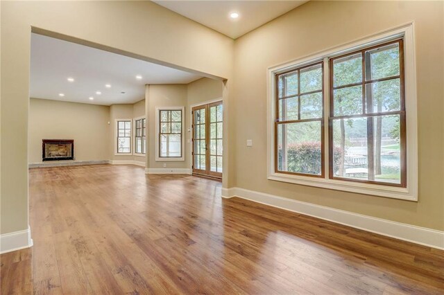 unfurnished living room featuring french doors and light hardwood / wood-style flooring