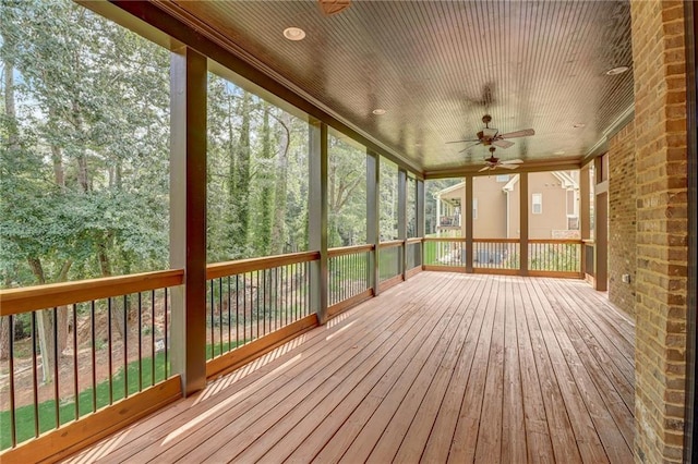 unfurnished sunroom featuring wood ceiling and ceiling fan