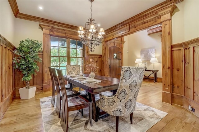 dining space featuring ornamental molding, light hardwood / wood-style floors, and a chandelier