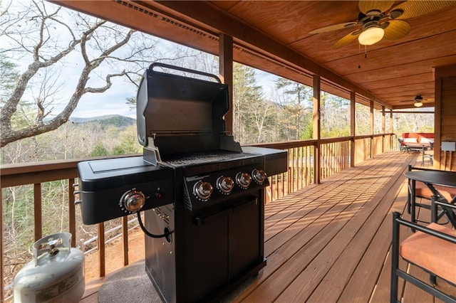 wooden deck featuring area for grilling and ceiling fan